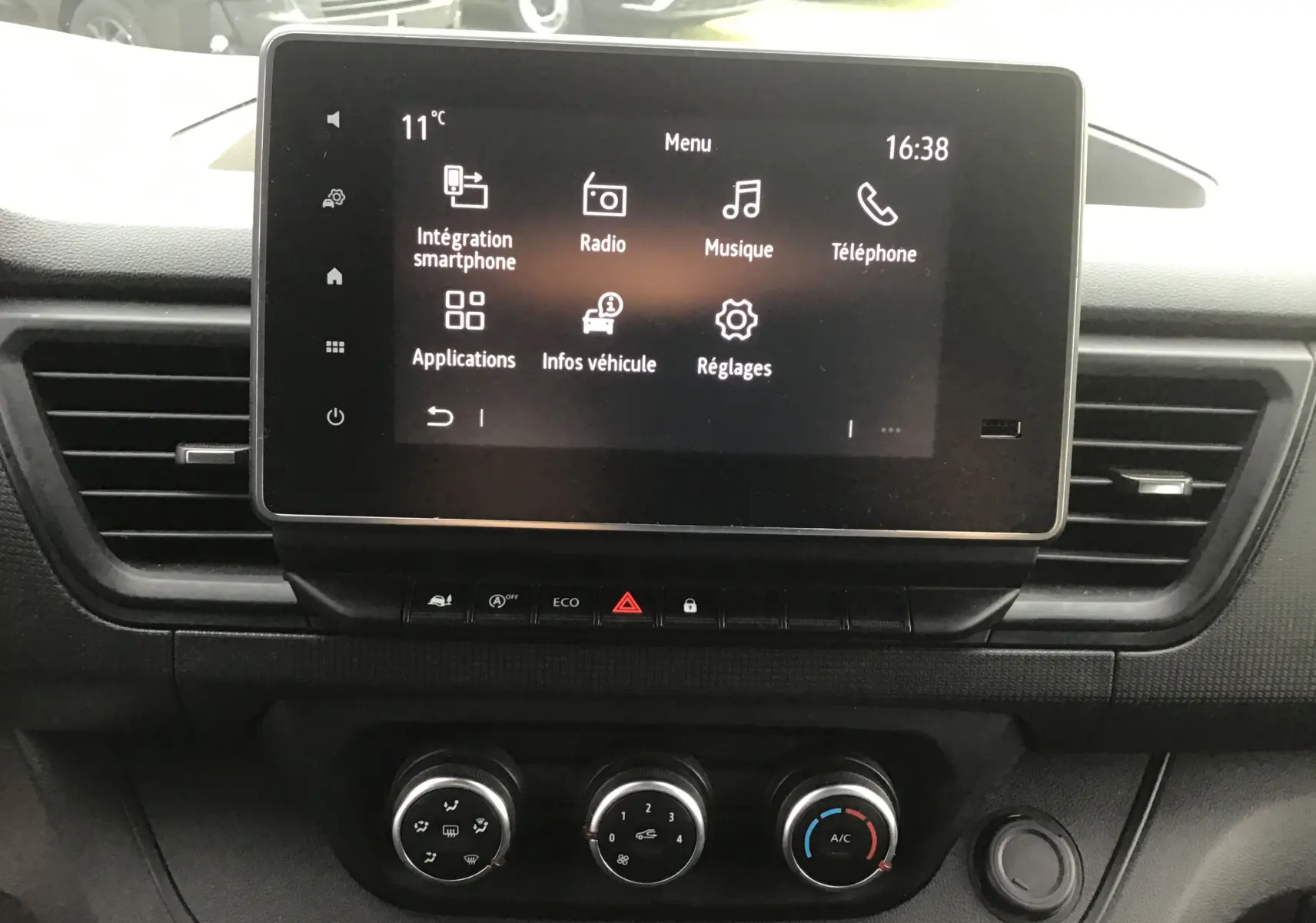 Vue rapprochée de l’écran tactile Easy Link 8 pouces et des commandes de climatisation du Renault Trafic Combi gris Highland 2022.