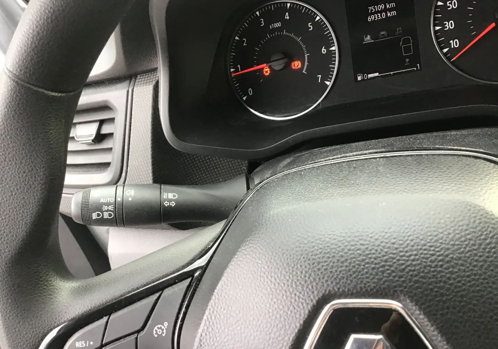 Vue rapprochée du tableau de bord et volant noir du Renault Trafic Combi avec compte-tours et affichage digital.