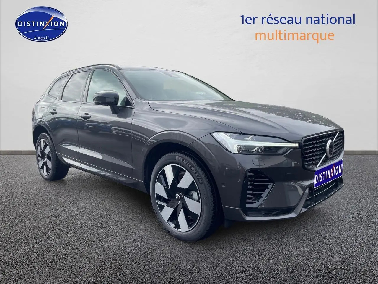 Vue 3/4 avant droite d’un Volvo XC60 gris brume métallisé avec jantes alu distinctives et calandre chromée.
