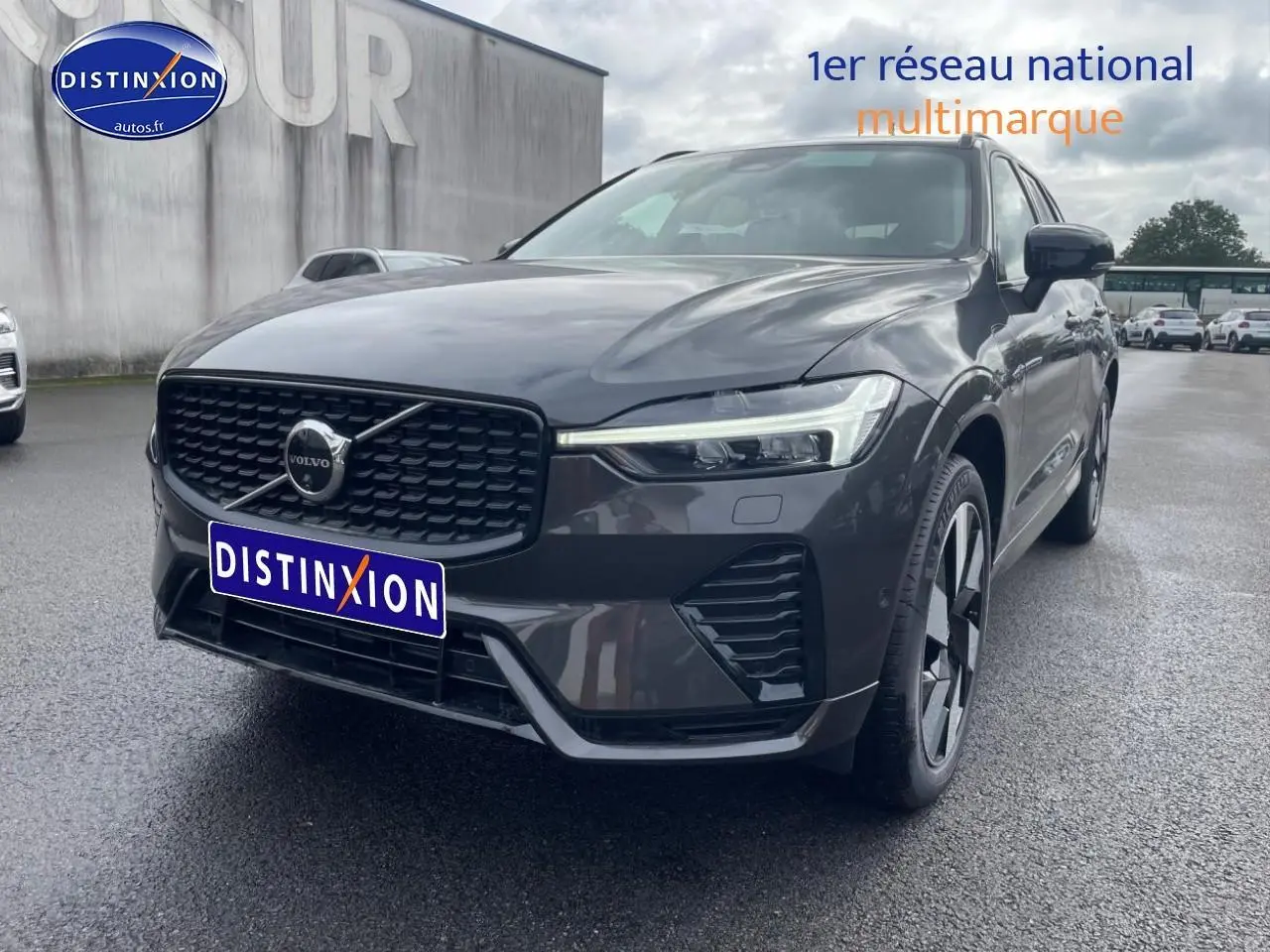 Vue 3/4 avant droite du Volvo XC60 gris métallisé avec calandre noire et jantes alu distinctives.