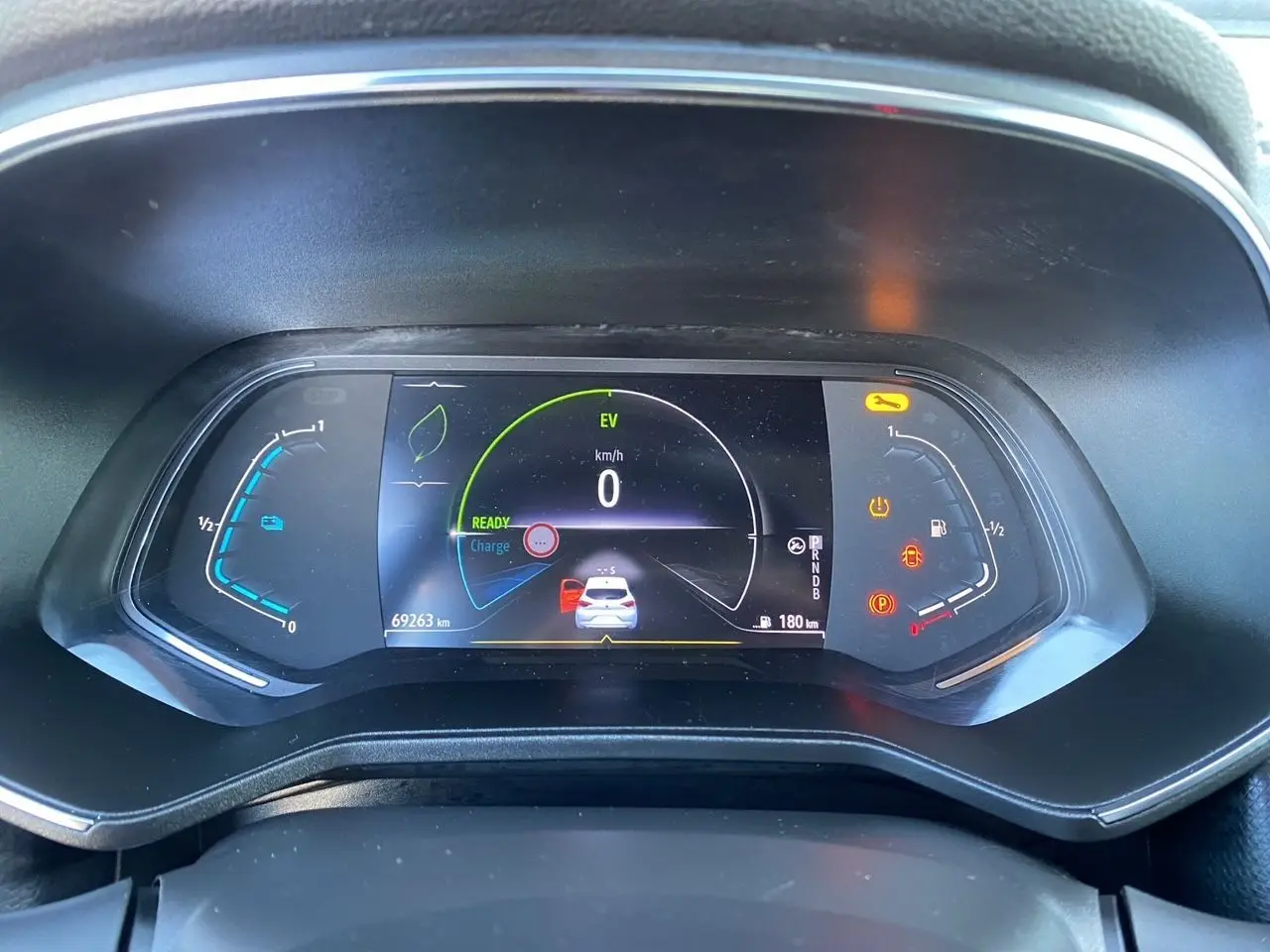 Vue rapprochée du tableau de bord numérique noir de la Renault Clio V E-Tech 140 hybride affichant 0 km/h et 69 263 km.