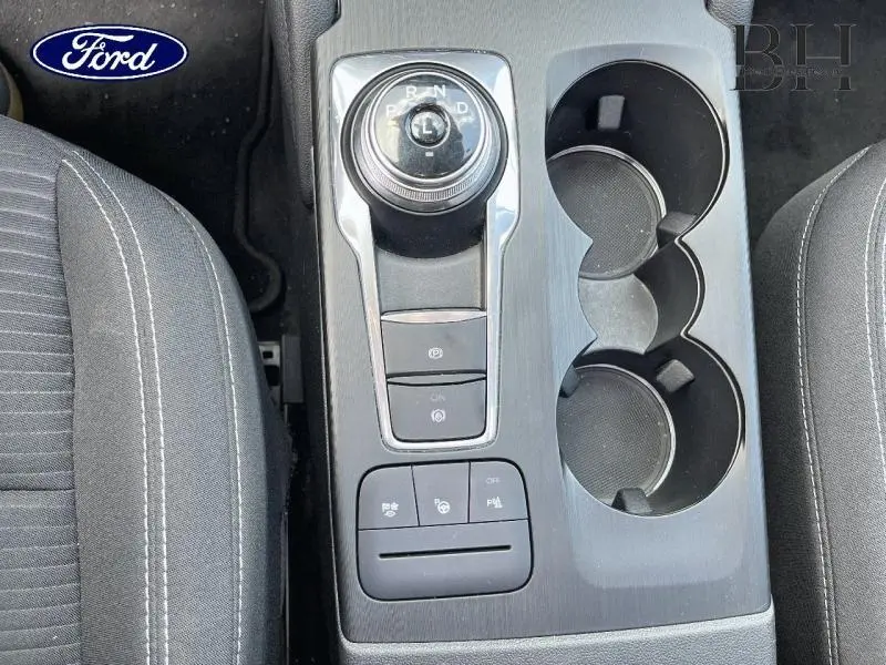 Vue plongeante sur la console centrale grise avec sélecteur rotatif de boîte auto et porte-gobelets du Ford Kuga 2022.