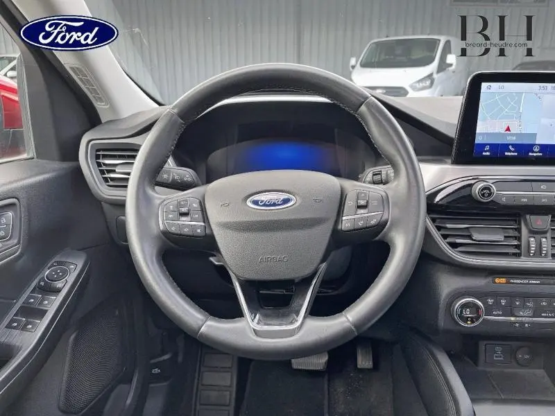 Vue intérieure centrée sur le volant cuir multifonction du Ford Kuga 2022 avec écran tactile et commandes au volant.