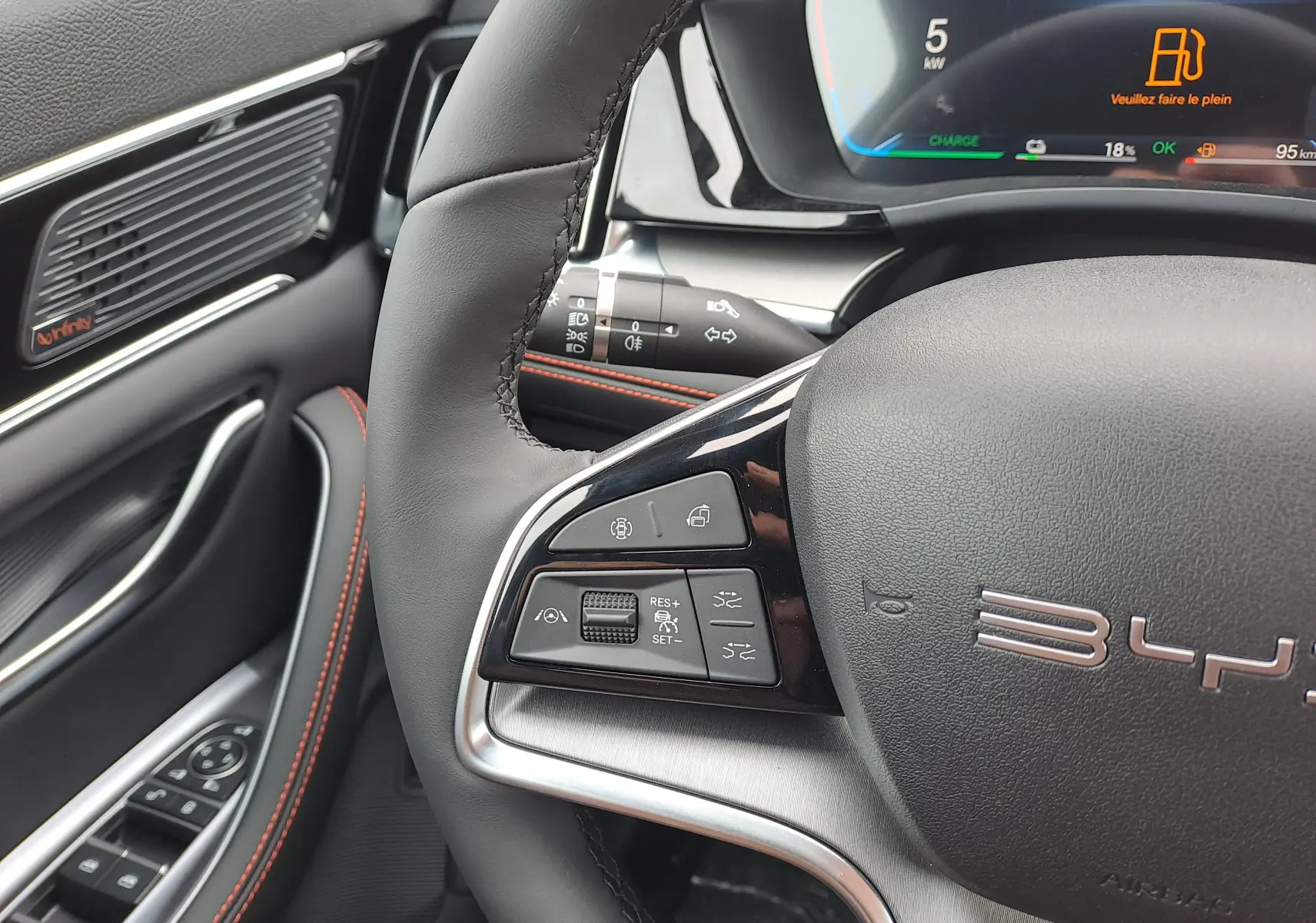Gros plan sur le volant noir du BYD SEAL U 2025 avec commandes multifonctions et tableau de bord numérique partiel.