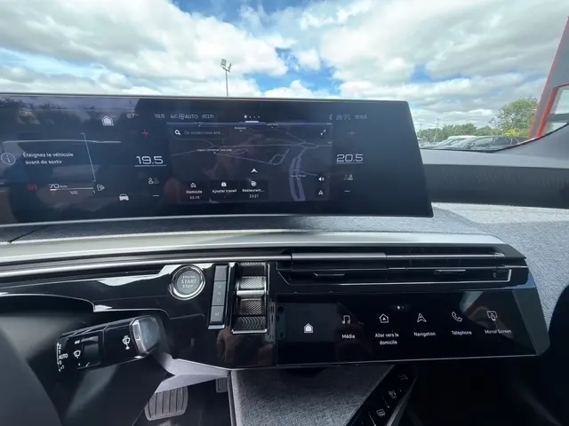 Tableau de bord intérieur du Peugeot 3008 hybride 2025 avec écran tactile large et bouton démarrage, vue de face.
