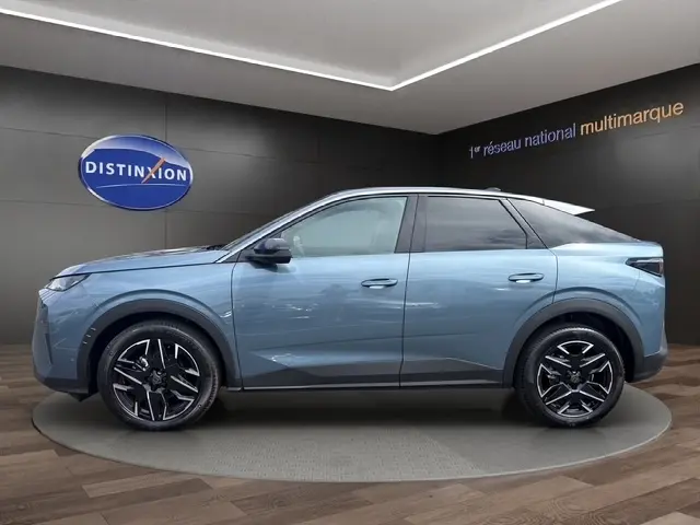 Vue de profil côté gauche d’un Peugeot 3008 bleu 2025 dans un showroom avec jantes noires et toit noir.