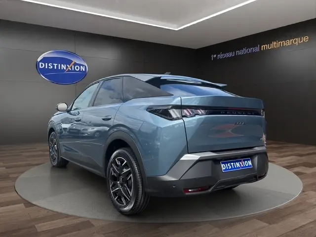 Vue 3/4 arrière droite d'un Peugeot 3008 bleu 2025 avec feux LED et jantes noires en showroom.