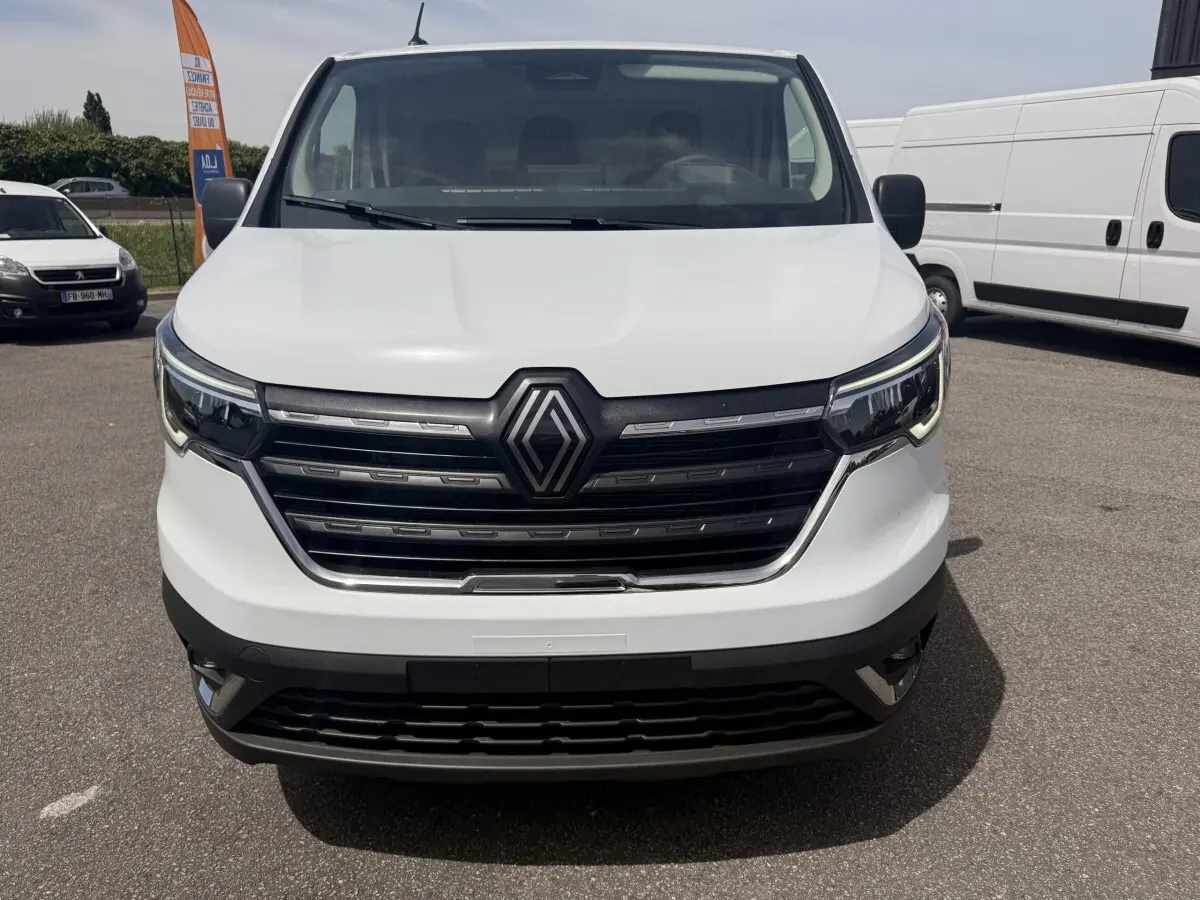 Vue de face du Renault Trafic Fourgon blanc 2025 avec calandre noire et phares LED distinctifs.