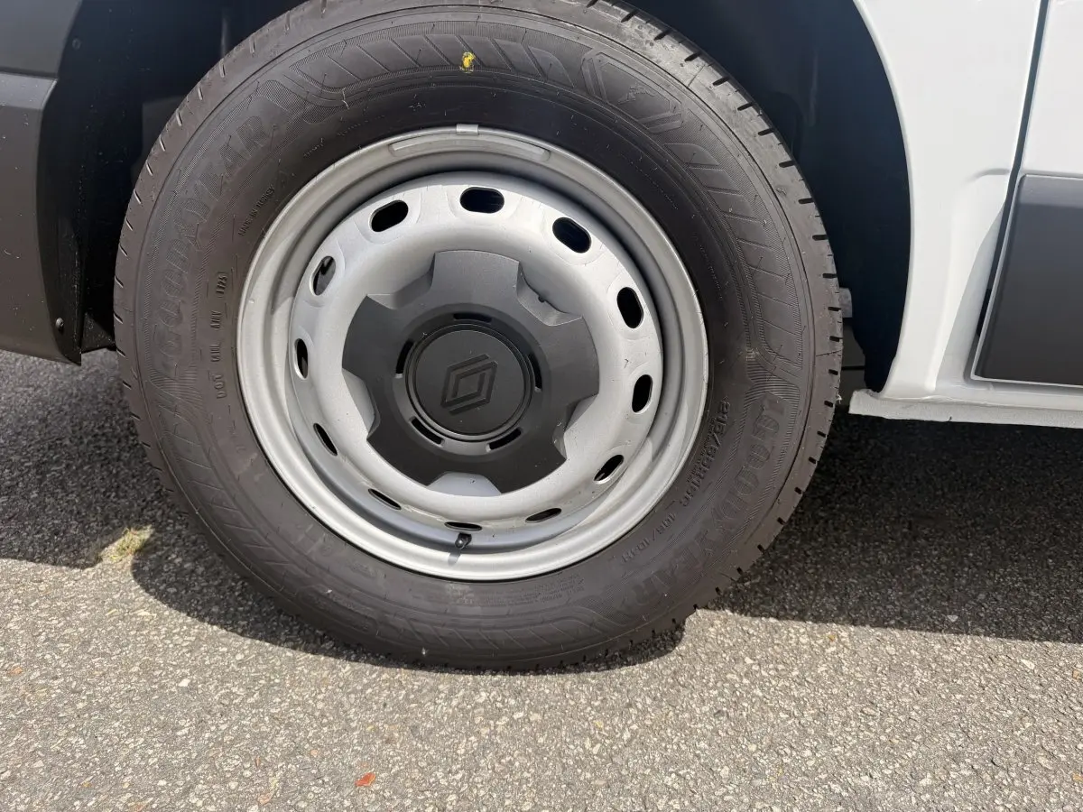 Gros plan sur la roue avant droite du Renault Trafic Fourgon blanc, mettant en valeur la jante acier et le logo central.