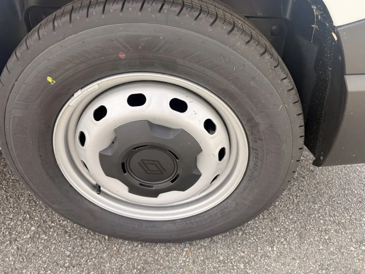 Gros plan sur la roue avant droite du Renault Trafic Fourgon blanc avec jante acier et logo Renault central.