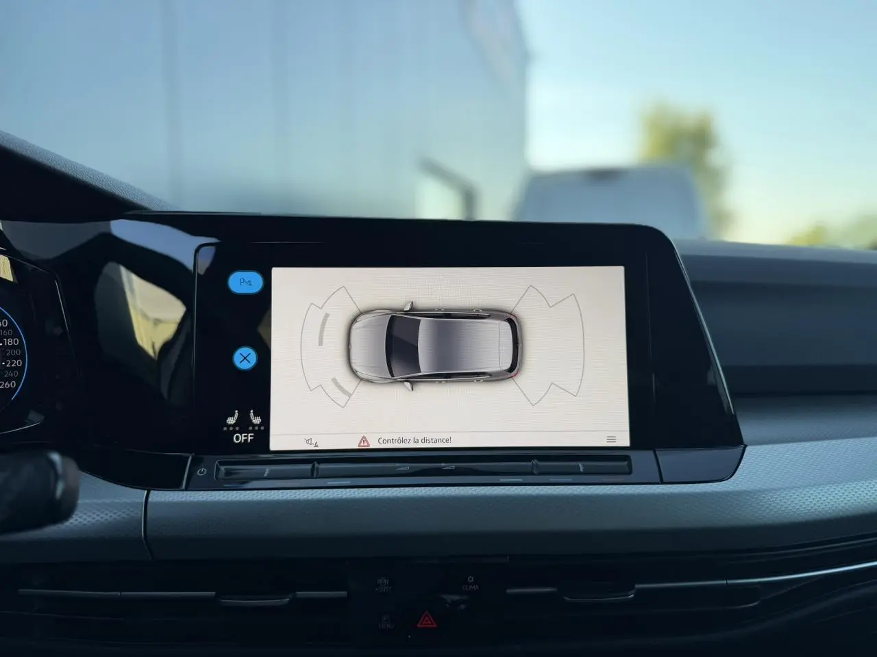 Vue intérieure sur l'écran tactile central affichant la caméra de recul de la Volkswagen Golf 8 blanche.