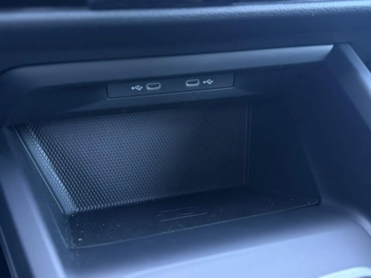 Gros plan sur la console centrale de la Volkswagen Golf 8 blanche, montrant deux ports USB-C intégrés.