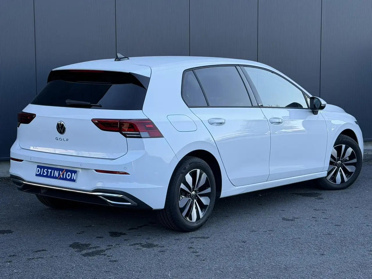 Volkswagen Golf 8 blanche vue 3/4 arrière droit, avec jantes alliage et feux arrière LED distinctifs.