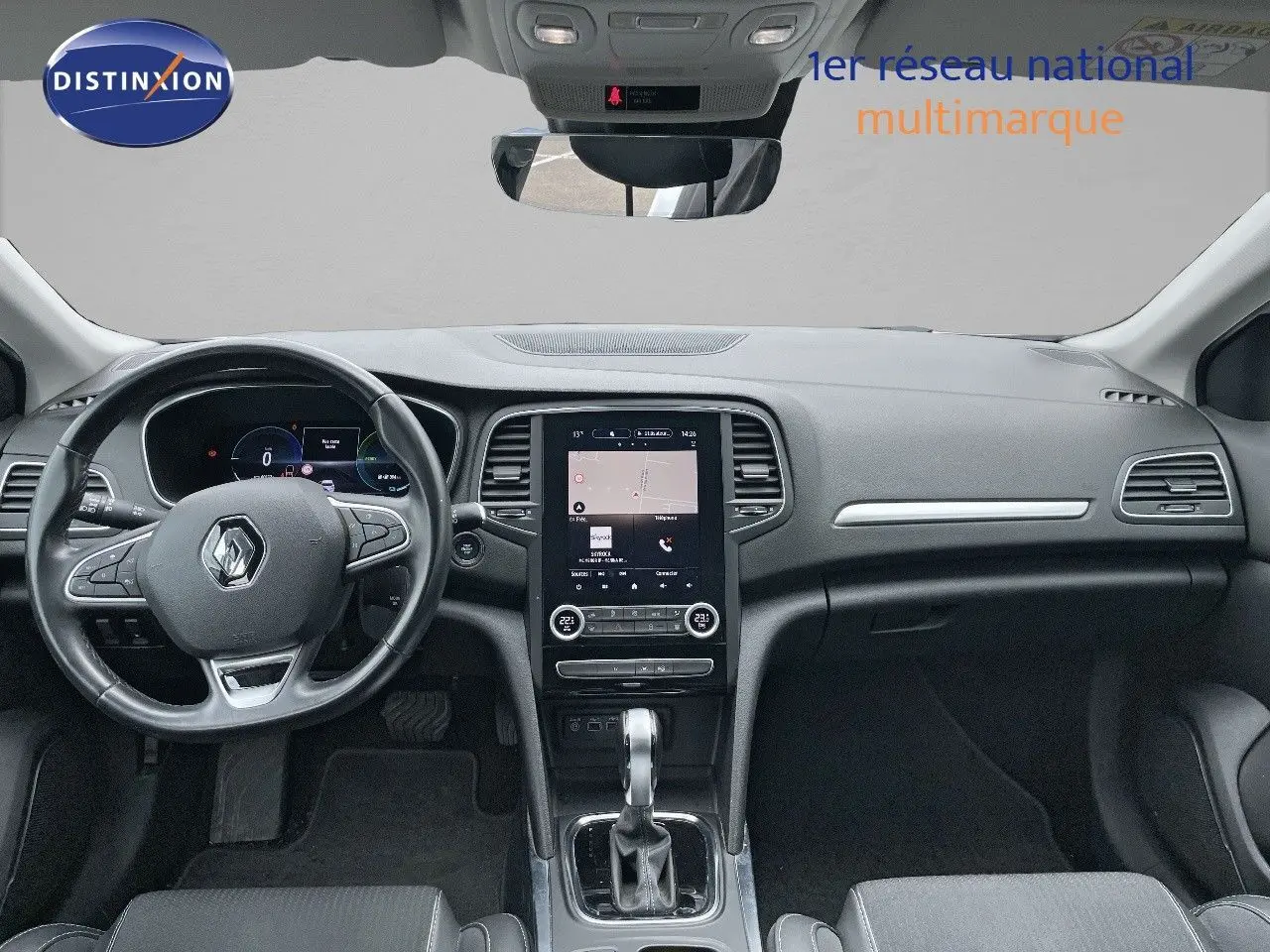 Vue intérieure frontale du tableau de bord de la Renault Mégane Break blanche Glacier, avec écran tactile central et volant multifonction.