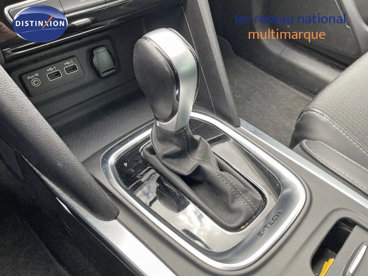 Le levier de vitesse automatique en gros plan dans l’habitacle de la Renault Mégane Break hybride blanche.