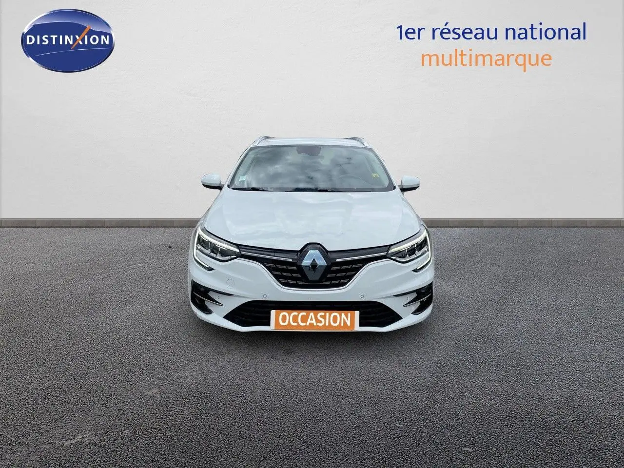 Vue frontale d'une Renault Mégane Break blanche Glacier avec calandre noire et feux LED allumés.