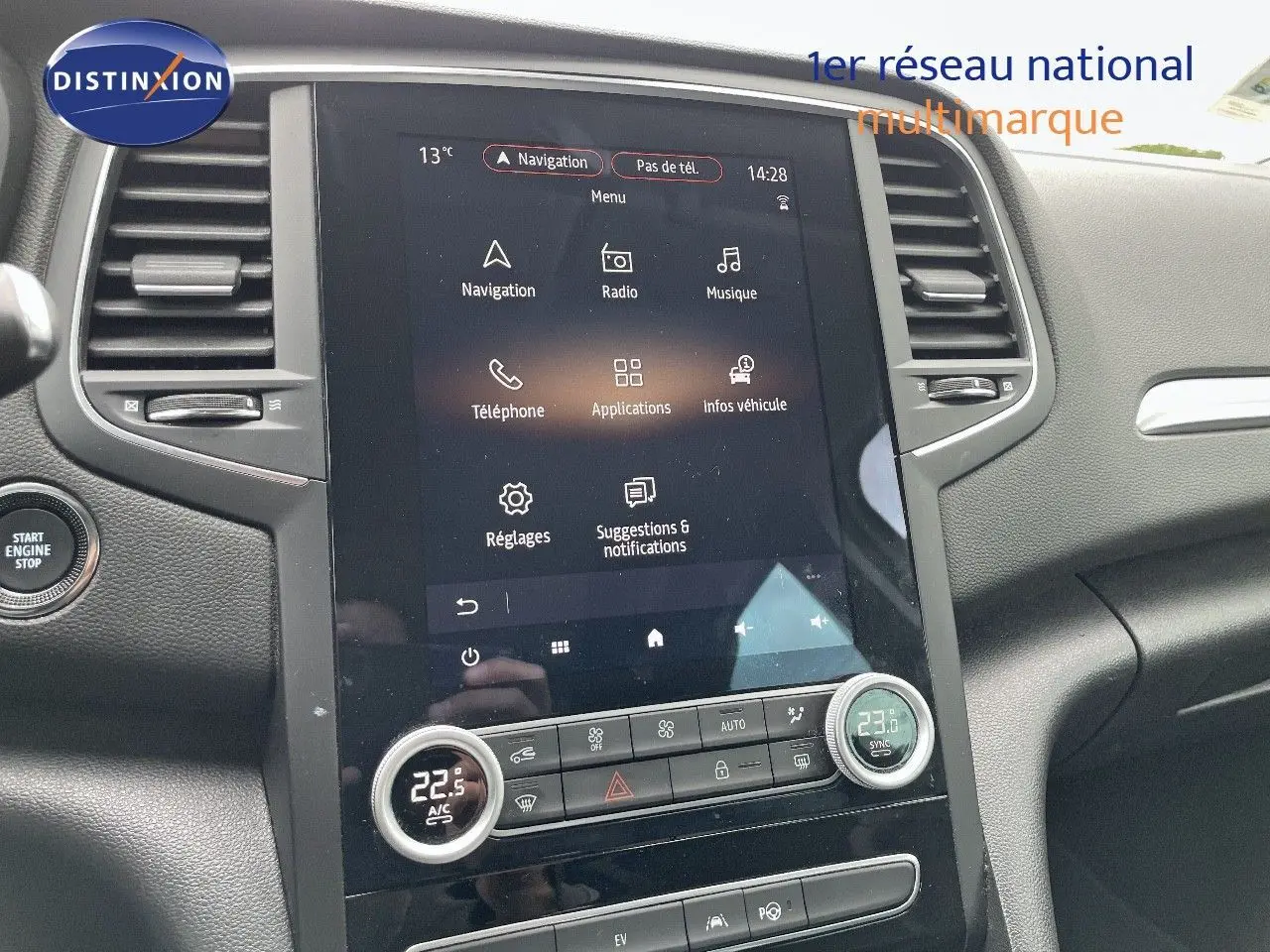 Vue intérieure centrée sur l'écran tactile et la console centrale du Renault Megane Break blanc Glacier 2021.