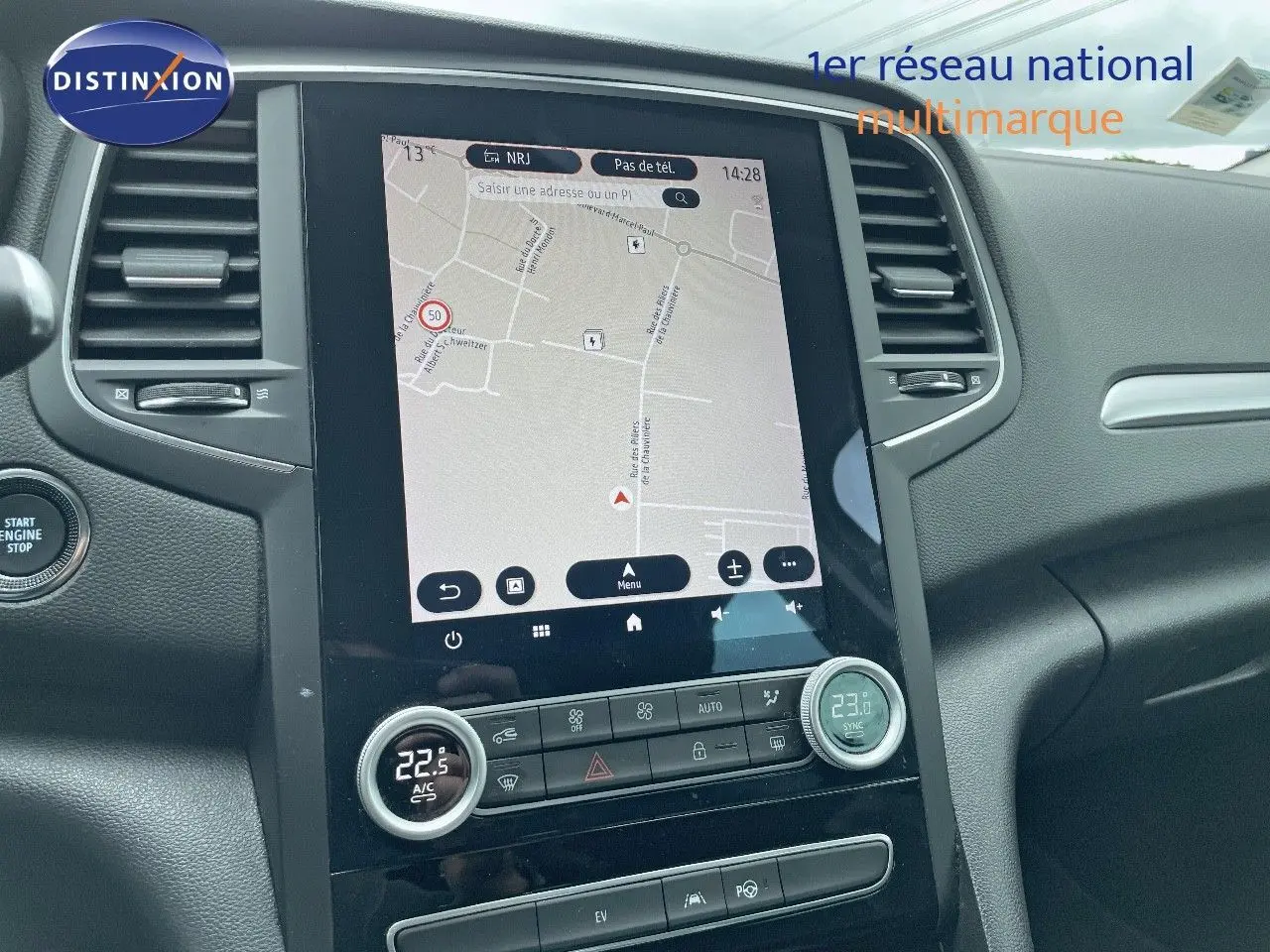 Vue rapprochée de la console centrale avec écran tactile et commandes de climatisation d’une Renault Mégane Break blanc glacier.