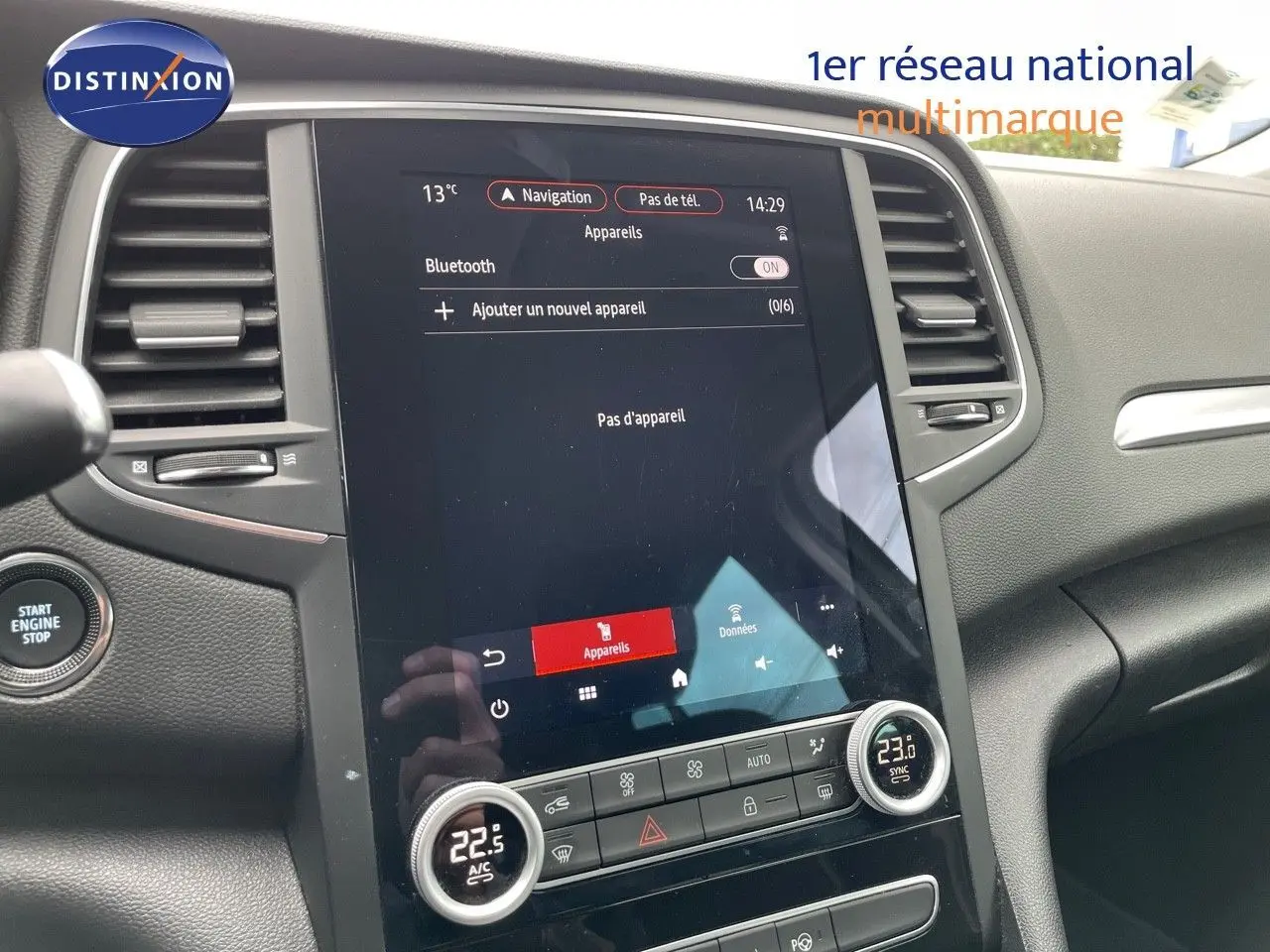 Vue intérieure centrée sur l’écran tactile et la console centrale du Renault Mégane Break blanc glacier, version 2021.