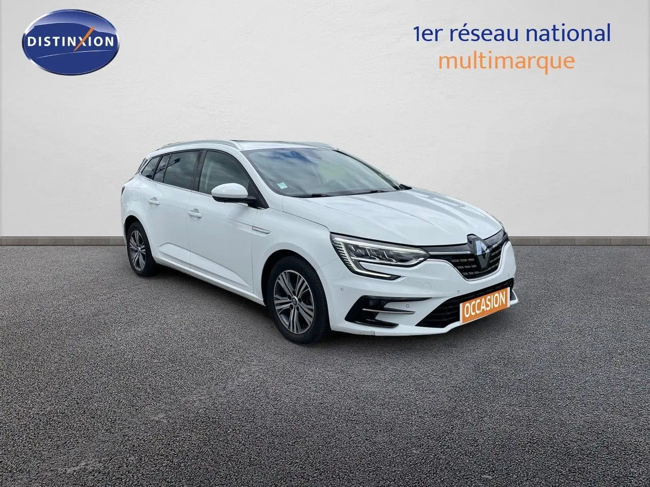 Renault Mégane Break blanc glacier vue 3/4 avant droit, avec phares LED et calandre noire distinctive.