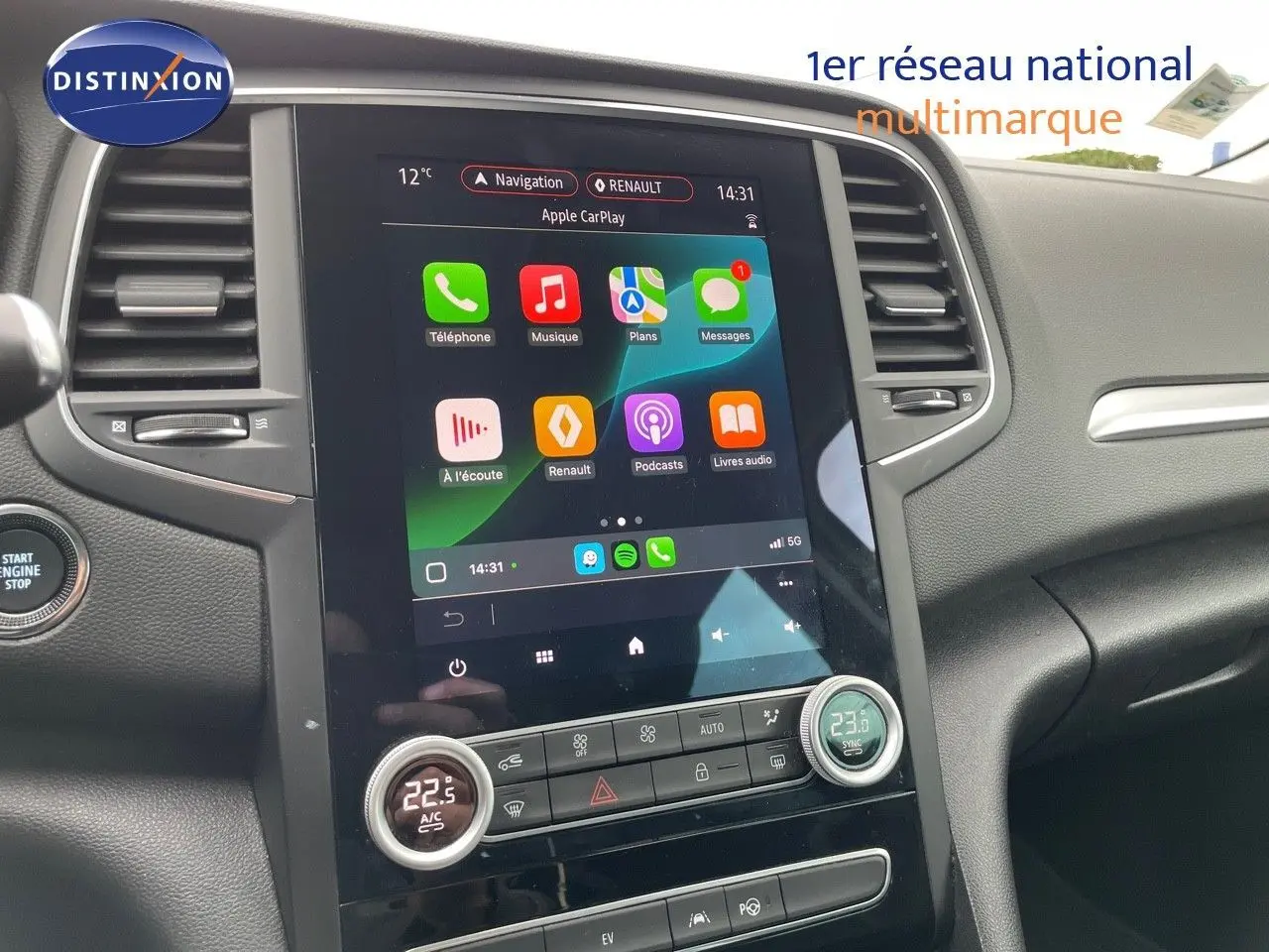 Vue intérieure centrée sur l'écran tactile du tableau de bord de la Renault Mégane Break blanc glacier, affichant Apple CarPlay.