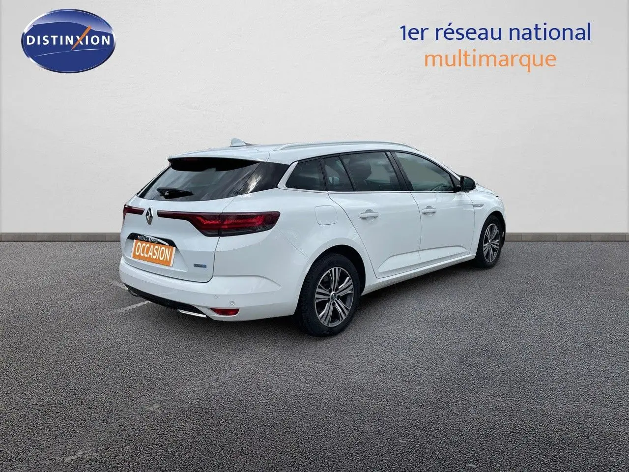 Vue 3/4 arrière droite d'une Renault Mégane Break blanc glacier avec feux arrière LED et jantes alliage.