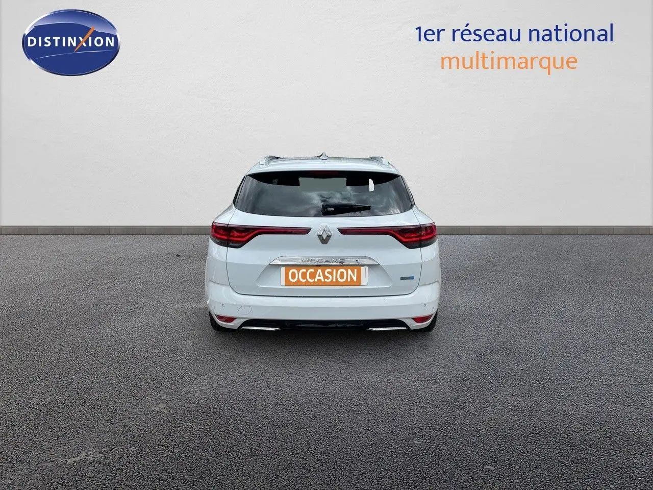 Vue arrière d'une Renault Mégane Break blanc glacier, avec feux LED et badge hybride rechargeable visible.