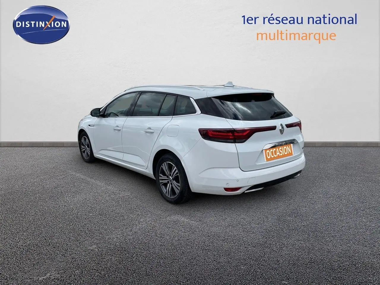 Vue 3/4 arrière droite d'une Renault Mégane Break blanc glacier hybride rechargeable avec feux arrière LED distinctifs.