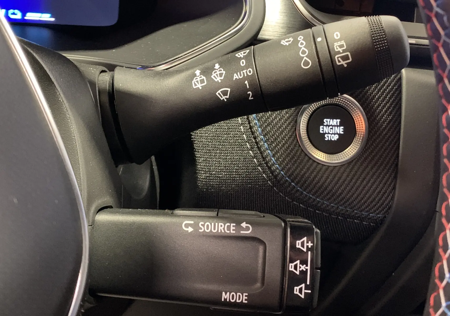 Gros plan sur la commande des essuie-glaces et bouton start dans l’habitacle du Renault Symbioz bleu iron.