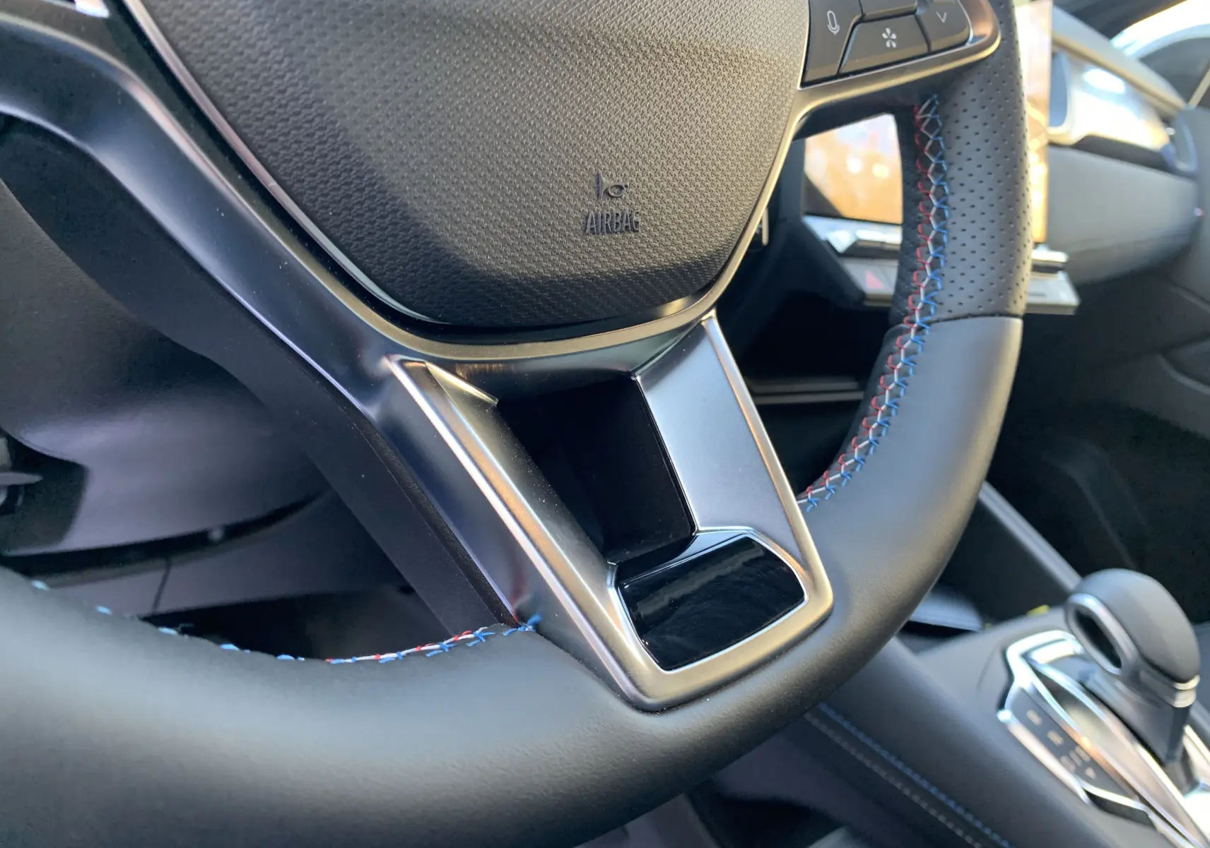 Gros plan sur le volant en cuir noir avec surpiqûres tricolores du Renault Symbioz E-Tech Full Hybrid 2025.