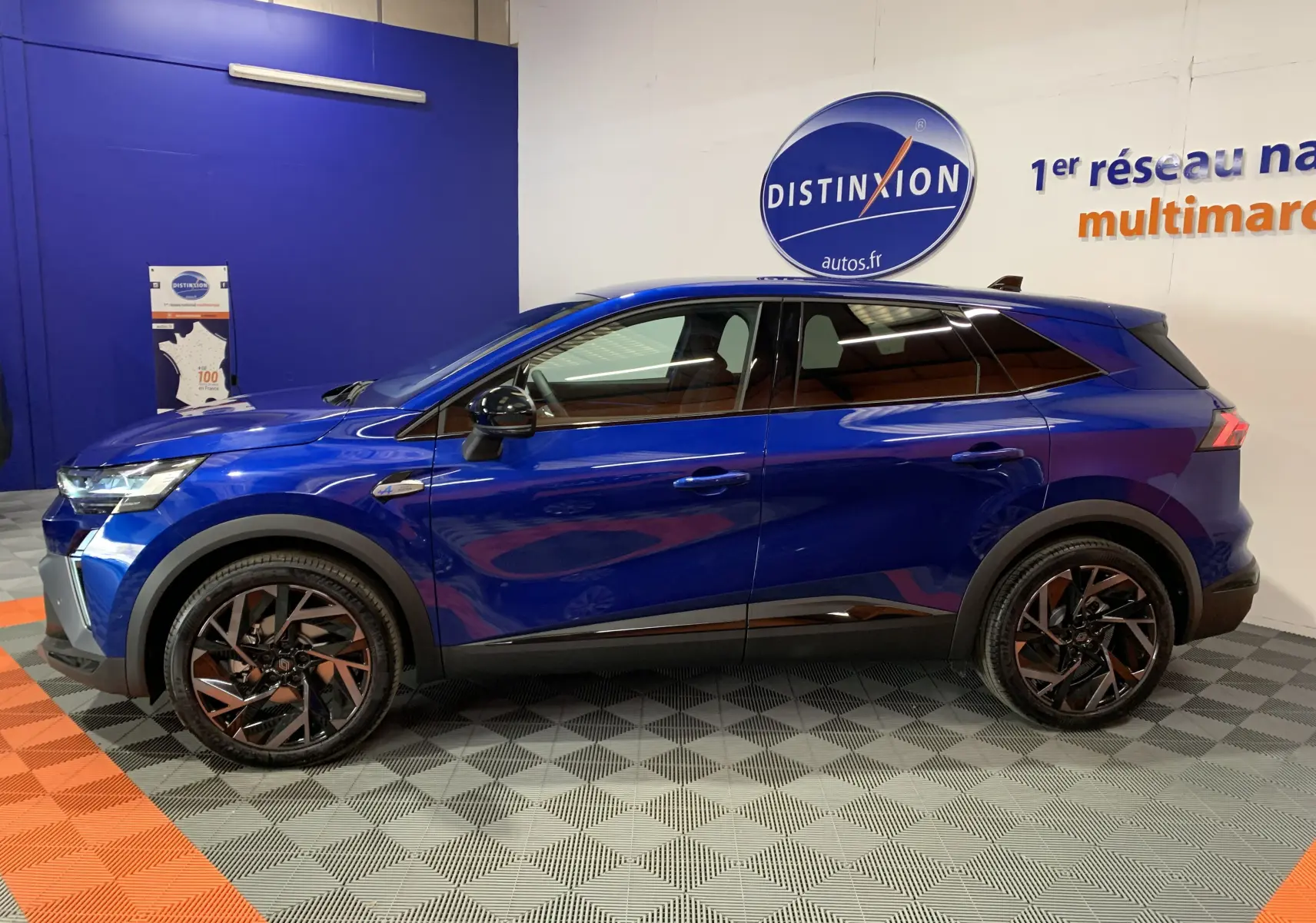 Profil côté gauche d'un Renault SYMBIOZ E-TECH bleu iron, avec jantes noires et détails noirs contrastants.