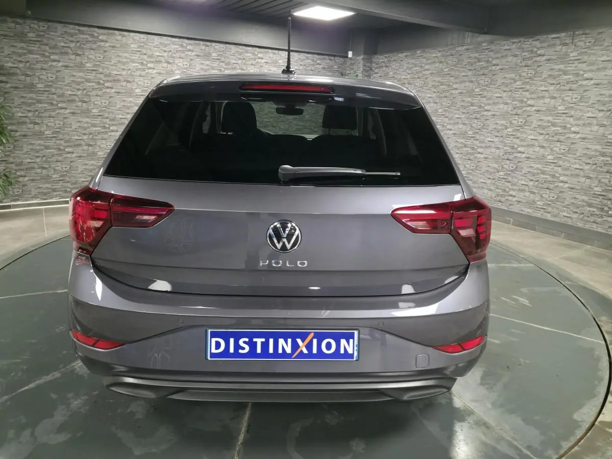 Vue arrière d'une Volkswagen Polo gris métallisé 2025 avec feux arrière LED et lunette arrière teintée.