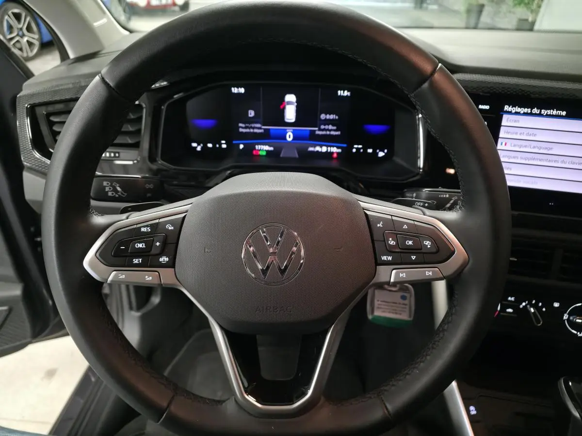 Vue intérieure centrée sur le volant cuir multifonction noir d'une Volkswagen Polo 2025 avec tableau de bord digital.