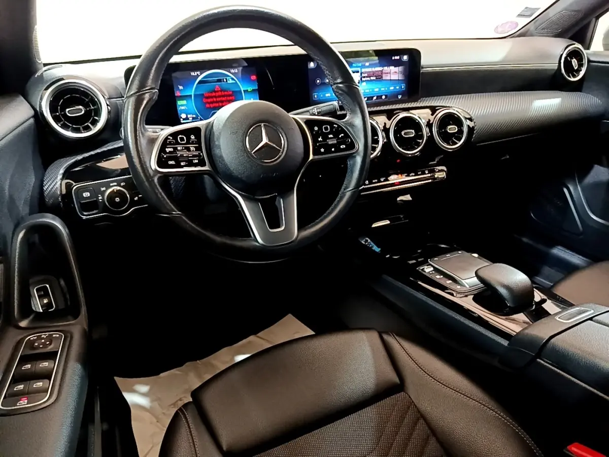 Intérieur noir de la Mercedes Classe A 250 e Business Line 2020, vue du poste de conduite avec tableau de bord numérique et volant cuir.