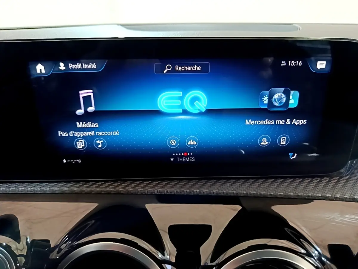 Écran tactile central bleu affichant l'interface Mercedes EQ dans l'habitacle d'une Classe A gris foncé.