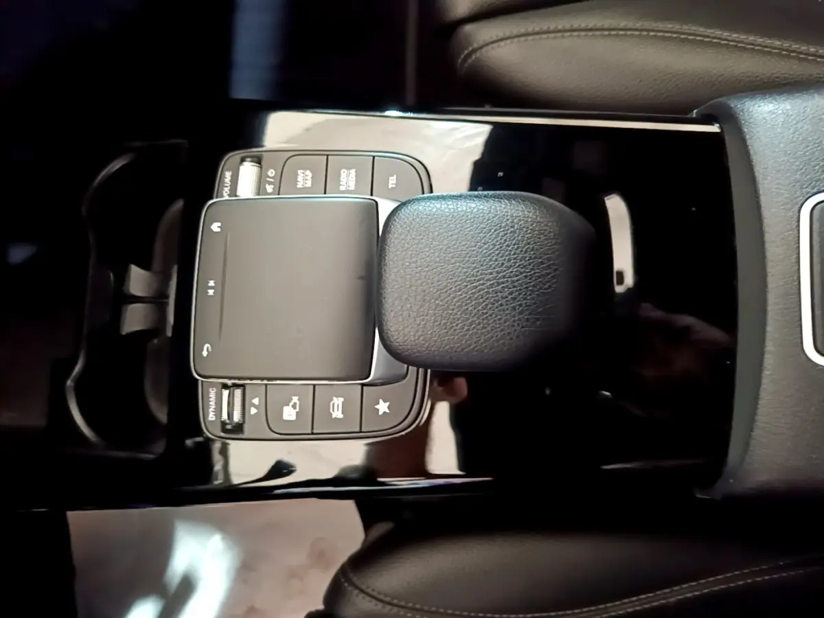 Vue rapprochée du pavé tactile et des commandes noires sur la console centrale d'une Mercedes Classe A gris foncé.
