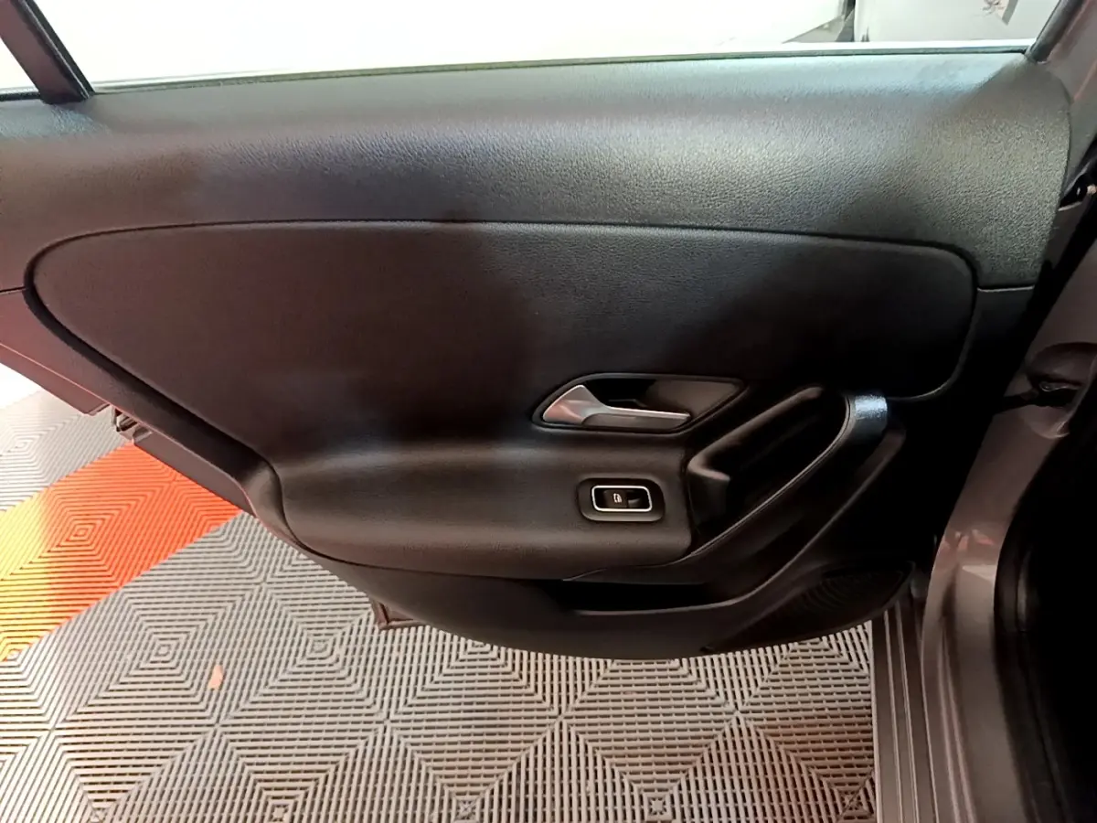 Gros plan sur la porte intérieure côté gauche d'une Mercedes Classe A 250 e Business Line gris foncé avec poignée argentée.
