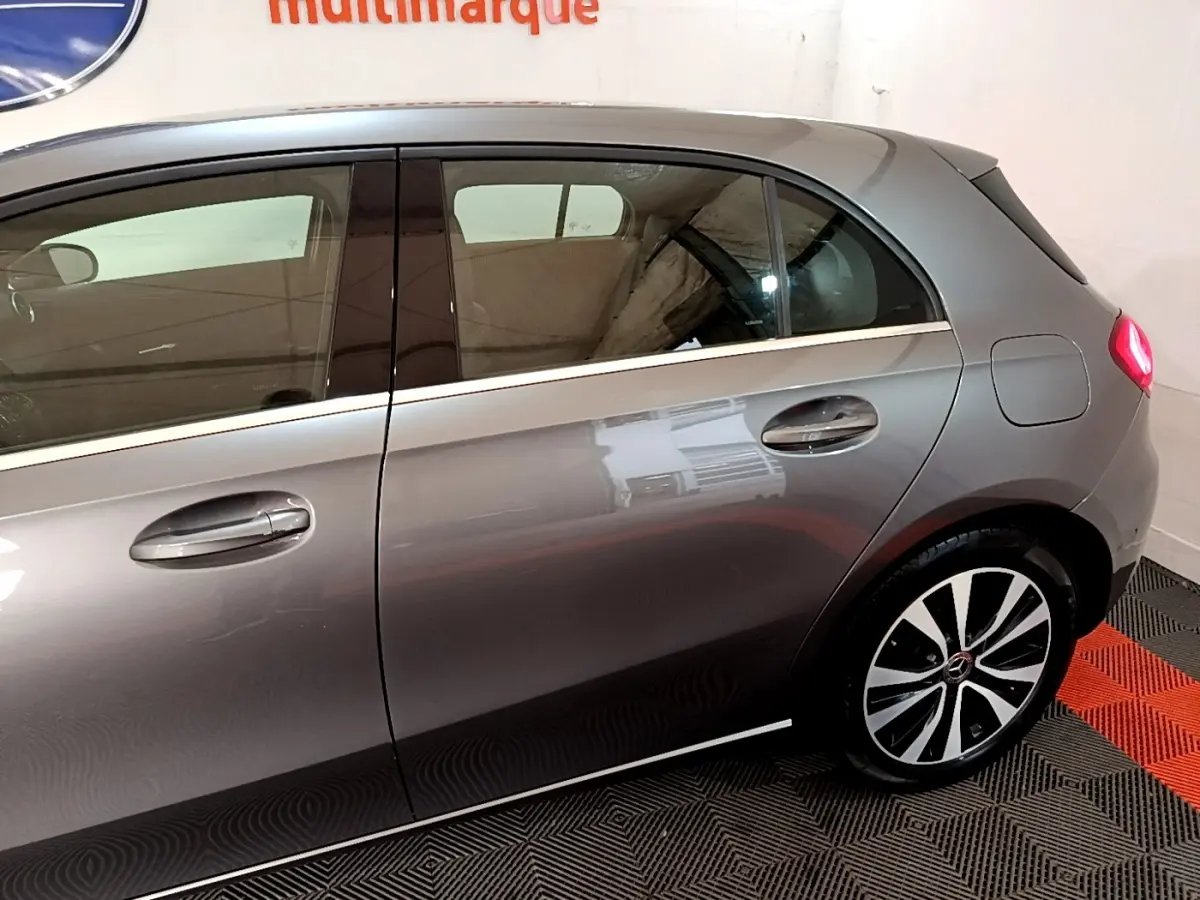 Profil côté droit d'une Mercedes Classe A 250 e Business Line gris foncé, avec jante alliage et feux arrière visibles.