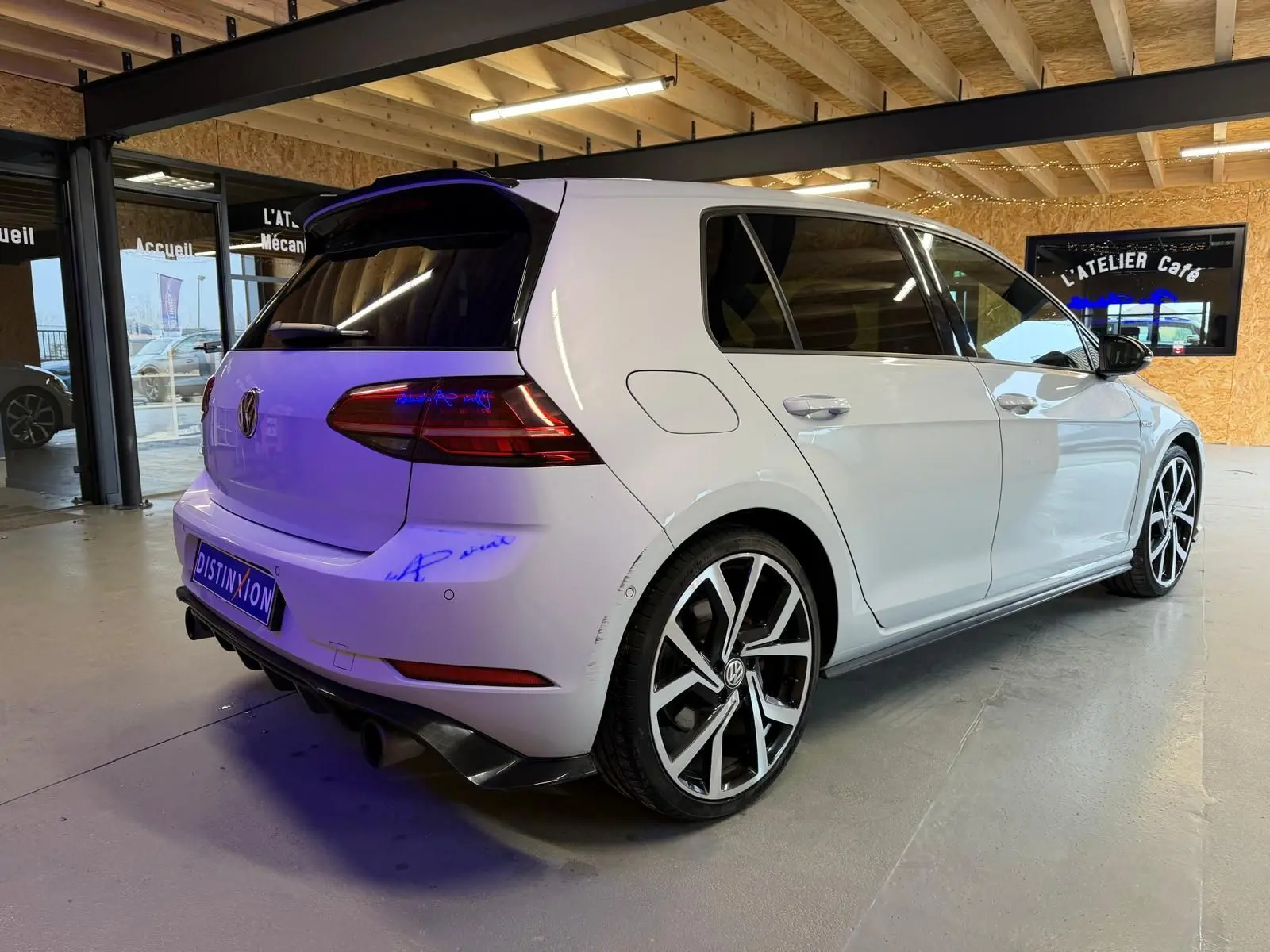 Vue 3/4 arrière droite d'une Volkswagen Golf GTI Performance gris clair avec jantes alu 19 pouces et sorties d'échappement chromées.