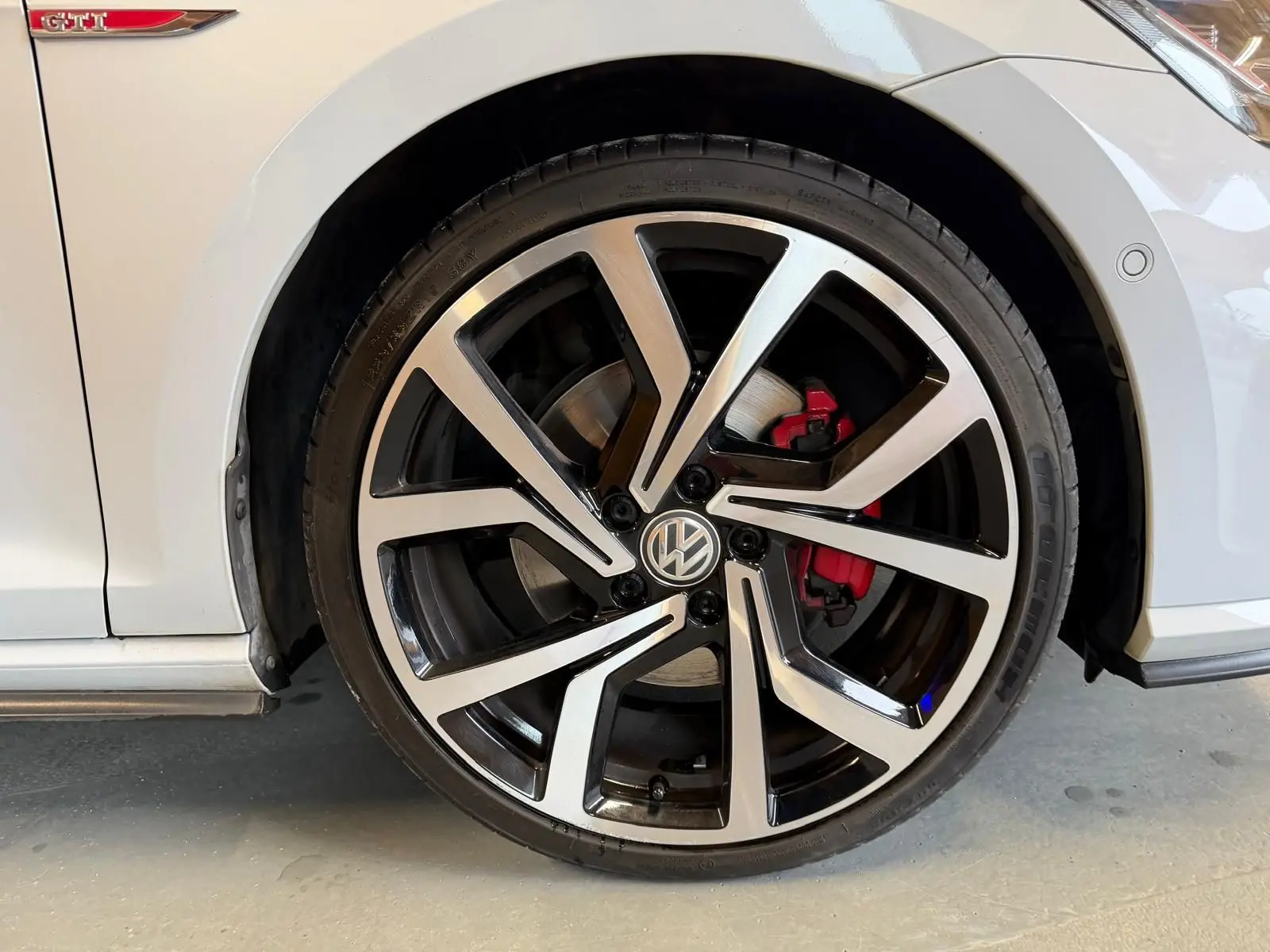 Vue intérieure du panneau de porte côté conducteur de la Volkswagen Golf GTI Performance gris, avec commandes électriques et insert rouge.