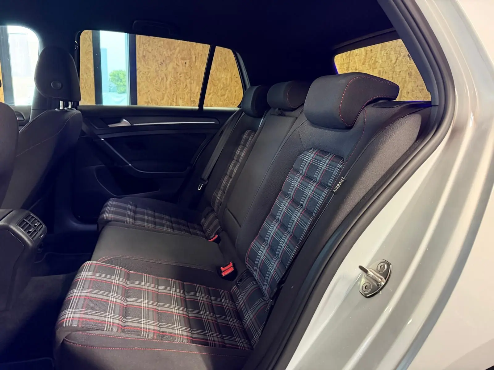 Vue intérieure côté droit des sièges arrière à motif tartan avec surpiqûres rouges dans une Volkswagen Golf GTI Performance gris 2018.