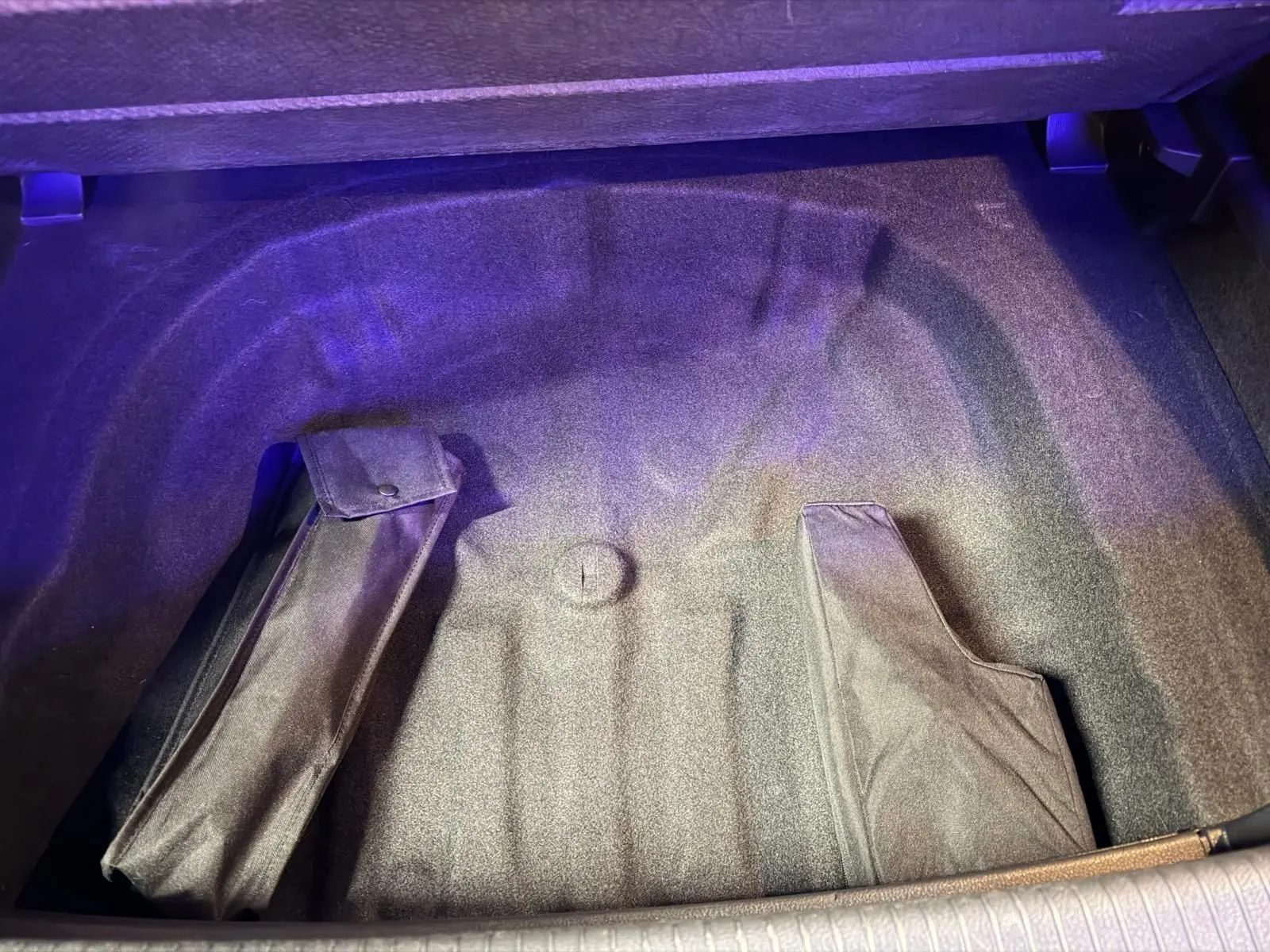 Vue intérieure arrière de la Volkswagen Golf GTI gris, montrant les sièges sport avec tissu à motif écossais et surpiqûres rouges.