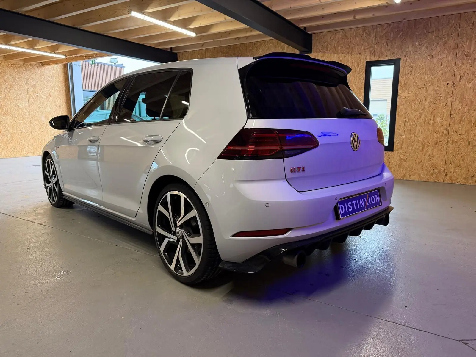 Gros plan sur la jante alu 19'' bicolore et l'étrier de frein rouge d'une Volkswagen Golf GTI Performance gris clair.