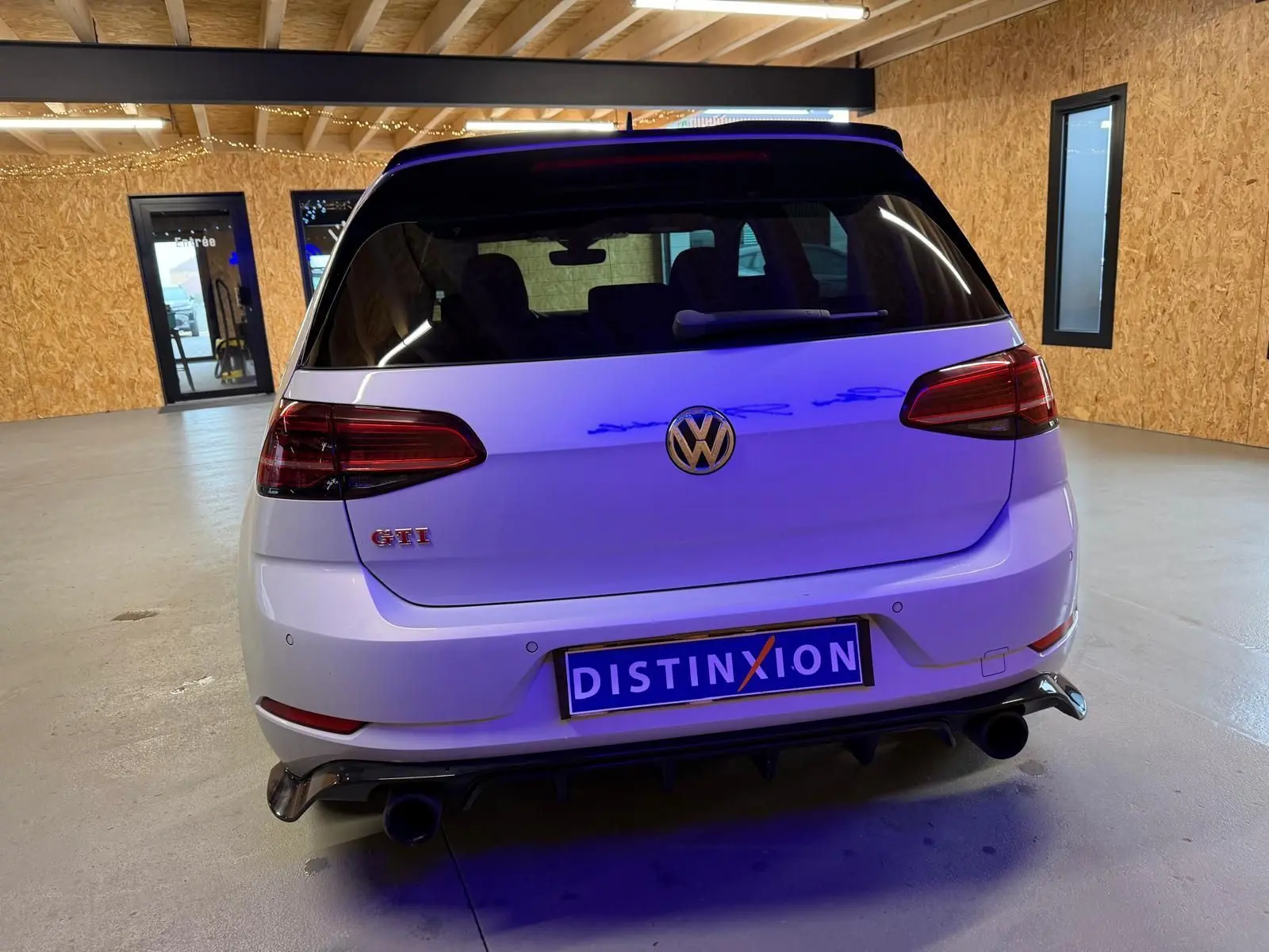 Vue arrière d'une Volkswagen Golf GTI Performance gris clair avec feux LED et double sortie d'échappement chromée.