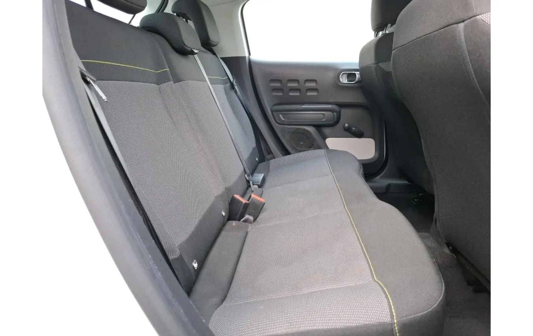 Vue latérale des sièges arrière gris foncé avec surpiqûres vertes d'une Citroën C3 1.5 BlueHDi 2021.