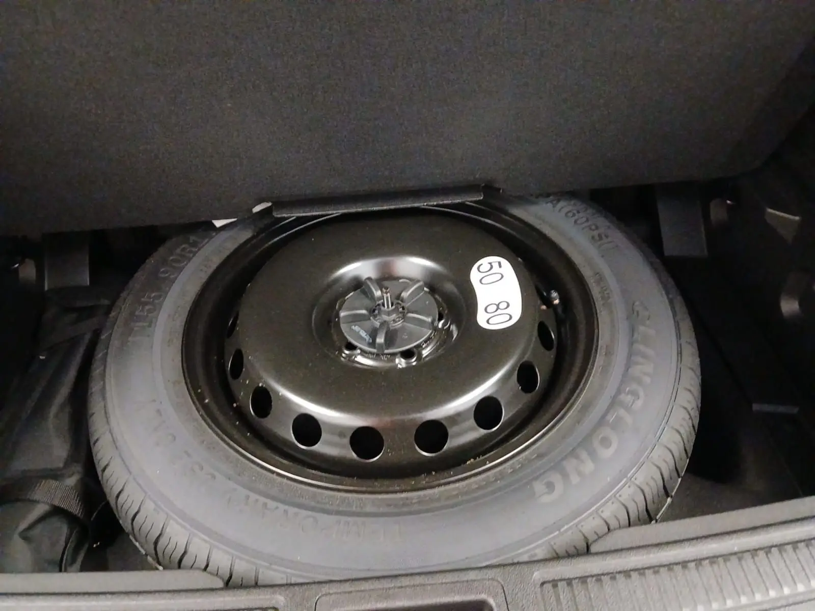 Gros plan sur la roue de secours temporaire noire dans le coffre du Renault Austral 2024 hybride.