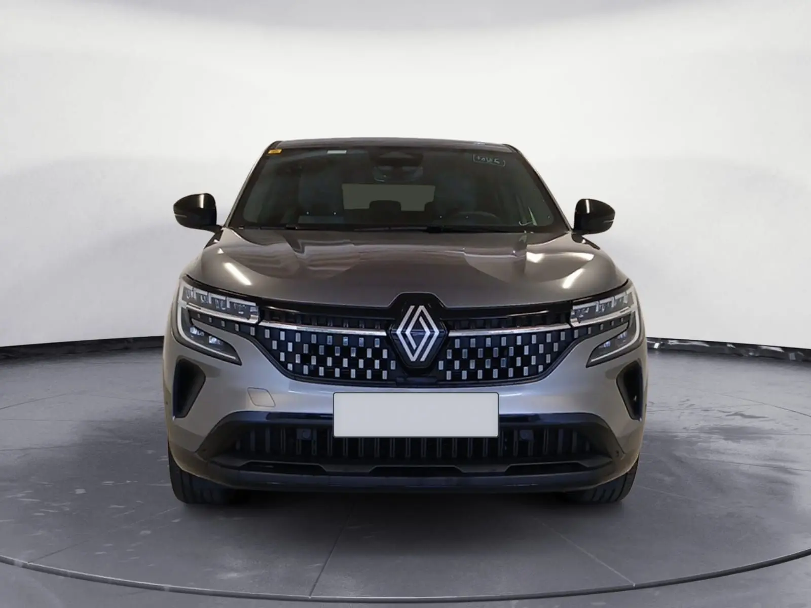 Vue frontale d'un Renault Austral 2024 gris métallisé avec calandre à damiers et feux LED adaptatifs.