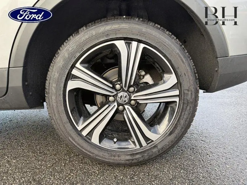 Gros plan sur la jante alu noire et argentée du MG ZS Cosmic Silver, mettant en valeur le logo MG central.