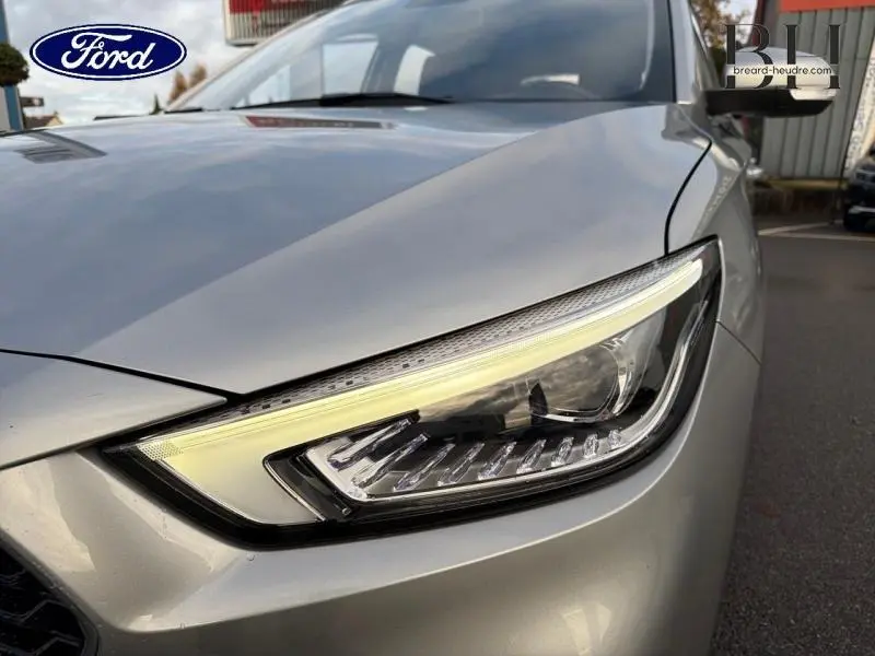 Gros plan sur le phare avant droit d'une MG ZS Cosmic Silver métallisée, soulignant ses lignes modernes et LED.