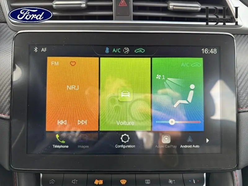 Écran tactile central de la console d’une MG ZS Cosmic Silver, affichant les commandes multimédia et climatisation.